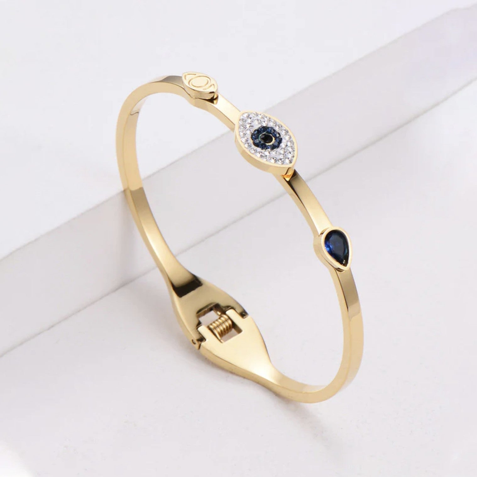 Evil Eye Bracelet, Gold-plated evil eye bracelet for women, Anti-tarnish stainless steel bracelet with diamond charm, Close-up of evil eye charm on bracelet, Bracelet styled with casual outfit, Slayink Bracelets