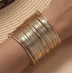 gold stacked wire cuff bracelet for women.
statement gold bangle with layered look.
bold gold open cuff bracelet for girls.
multi-layer gold-plated fashion bracelet.