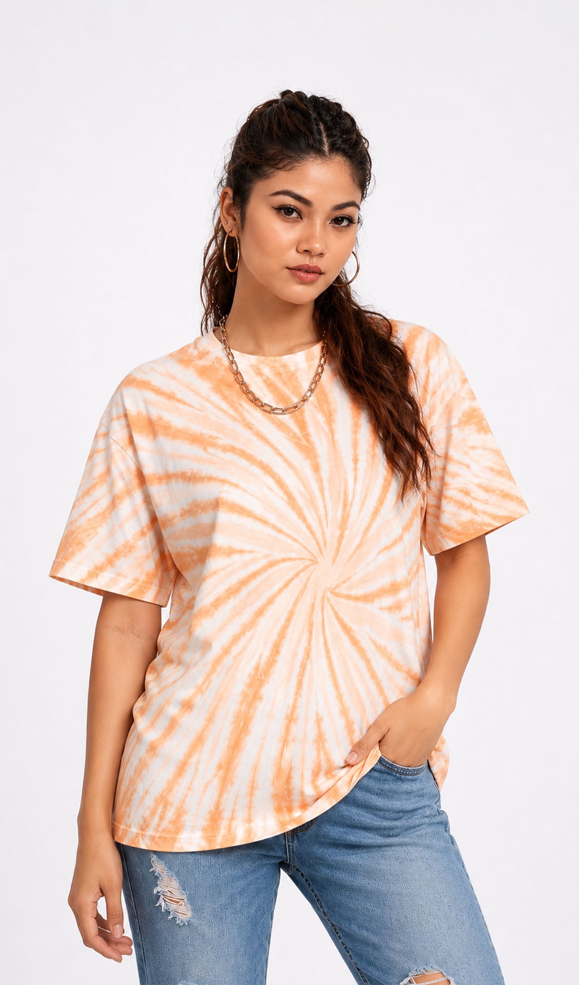 Woman wearing a tie-dye shirt and ripped jeans on a white background.Tie & dye t-shirt, women t-shirt, cotton t-shirt, casual outfit, trending t-shirt, Slayink orange tie & dye t-shirt, Slayink women tie & dye t-shirt, orange tie dye t-shirt women, oversized t-shirt , cotton t-shirt for women, summer t-shirt women, college wear t-shirt for girls, beach wear t-shirt women, gym wear t-shirt women, trendy college wear, pastel top, women's workout t-shirt, gym t-shirt women, ladies top, cotton t-shirt, trendy