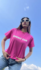 A woman wearing a bubble gum pink graphic t-shirt and sunglasses, standing against a blue sky.pink graphic t-shirt for women, women's graphic tee, 100% cotton t-shirt, cotton t-shirt women,casual t-shirt for women
regular fit t-shirt women, printed t-shirt women, cute graphic tee, aesthetic t-shirt women, Korean aesthetic clothing
streetwear t-shirt women, everyday cotton tee, summer t-shirt women, trendy graphic t-shirt, college outfit women, travel outfit women, soft cotton t-shirt .