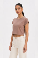 Woman wearing a brown cropped t-shirt and white pants on a plain background. brown cotton crop top. aesthetic fashion top. Comfortable cotton crop top in latte brown shade.Basic brown crop top for casual and layered outfits. Trendy brown cotton crop top for women’s fashion store. Soft stretch cotton brown crop top for daily wear. Brown fitted crop top with clean minimal design. Cotton cap sleeve crop top in earthy brown tone.
Women’s latte brown cropped cotton t-shirt top. Casual chic brown cotton crop top 