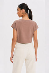 Woman wearing a brown t-shirt and white pants on a white background. brown cotton crop top. aesthetic fashion top. Comfortable cotton crop top in latte brown shade.Basic brown crop top for casual and layered outfits. Trendy brown cotton crop top for women’s fashion store. Soft stretch cotton brown crop top for daily wear. Brown fitted crop top with clean minimal design. Cotton cap sleeve crop top in earthy brown tone.
Women’s latte brown cropped cotton t-shirt top. Casual chic brown cotton crop top for Gen 