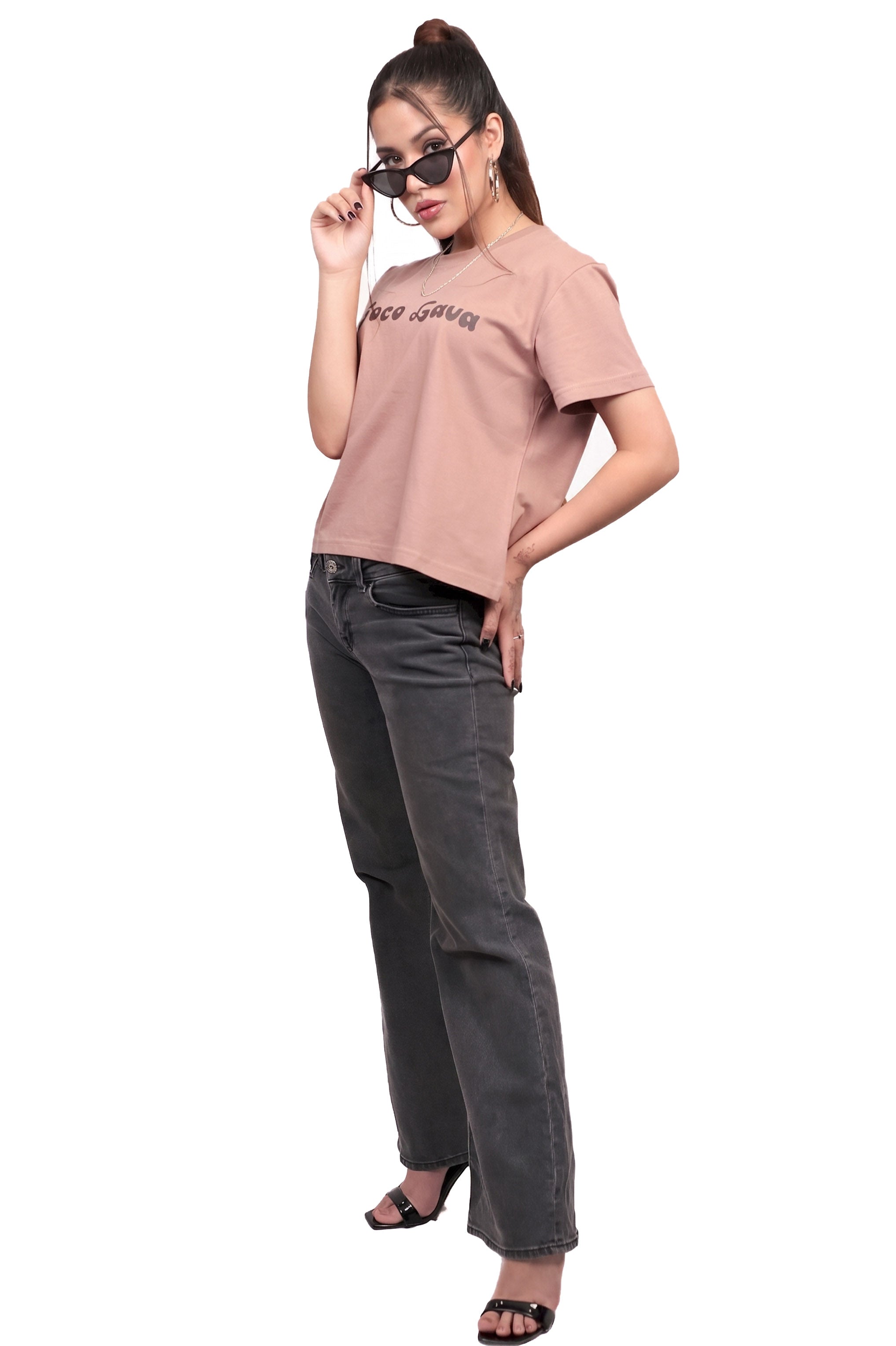 Woman wearing a brown cotton t-shirt and gray jeans on a white background.
GraphicTee, Cotton t-shirt, best cotton t-shirts for summer, brown t-shirt, printed t-shirt, affordable graphic t-shirts women, cute printed cotton tee for daily wear, trendy graphic crop top India, brown graphic cotton t-shirt.