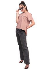 Woman wearing a brown cotton t-shirt and gray jeans on a white background.
GraphicTee, Cotton t-shirt, best cotton t-shirts for summer, brown t-shirt, printed t-shirt, affordable graphic t-shirts women, cute printed cotton tee for daily wear, trendy graphic crop top India, brown graphic cotton t-shirt.