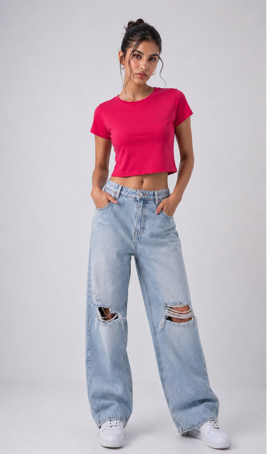 Woman wearing a bright pink crop top and light blue ripped jeans on a white background, showcasing a trendy pink crop top for women. Stylish hot pink top with a modern cropped fit, perfect for college outfit ideas, casual fashion, and crop top trends. Fashionable women's pink top paired with distressed denim jeans, ideal for everyday wear, street style, and trendy crop top looks for girls and women. Dark pink crop top inspired by popular fashion trends, suitable for casual outing.