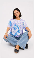 Person wearing a tie-dye shirt and jeans sitting on the floor against a white background.Slayink women Tie & dye tshirt, Slayink women t-Shirt,Oversized T-shirt, Oversized tie & dye T-shirt, oversized t-shirt, trendy college wear,casual wear, pastel top, women workout t-shirt,gym t-shirt women, ladies top, cotton t-shirt, trending top, baggy top, gym tee, loose tshirts for ladies, gym shirt , purple top, tie dye t-shirt women, Soft Girl Fashion, affordable  t-shirt, printed t-shirt women, college wear.