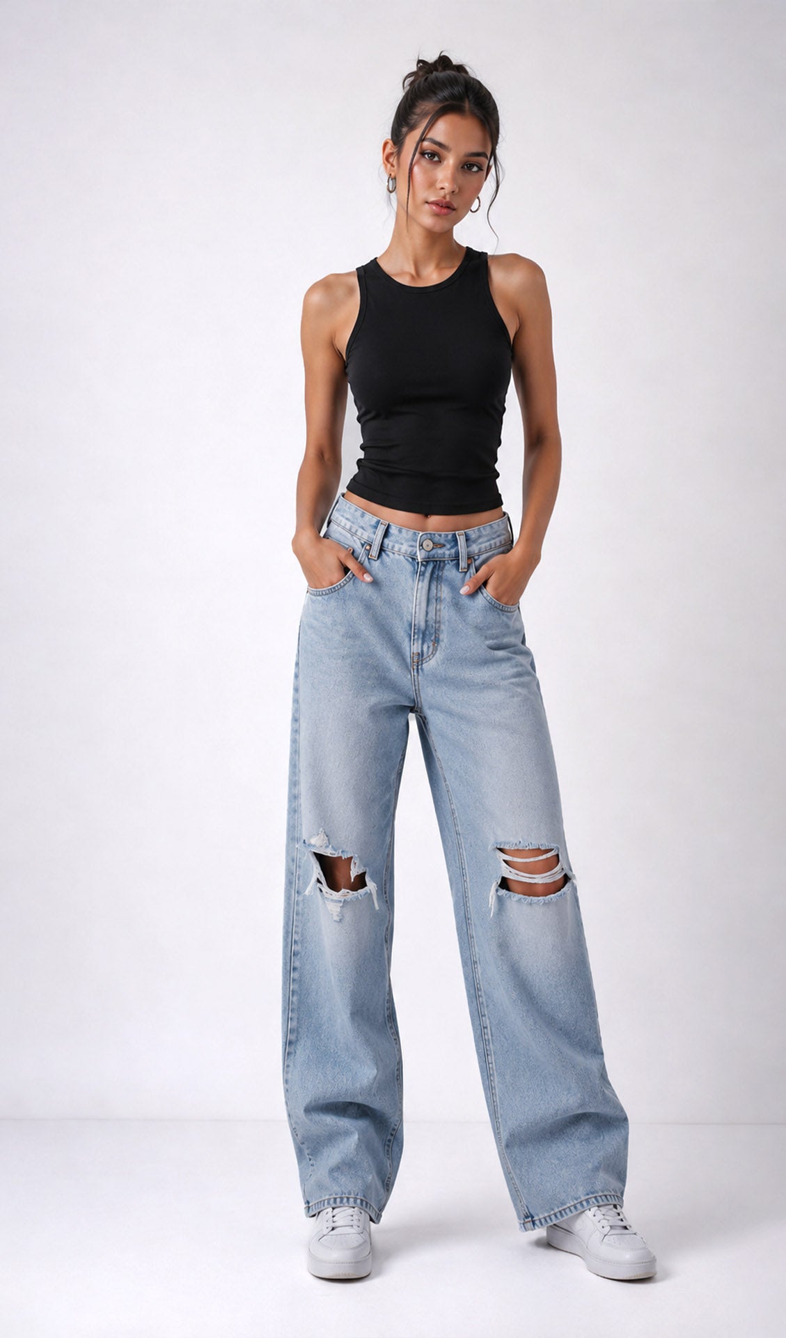 Woman wearing a black tank top and light blue jeans with rips on a white background.black tank top, black tank top women, women's black tank top, black sleeveless top, black camisole top, black vest top women, black summer top, basic black tank top, fitted black tank top, ribbed black tank top, casual black top, trendy black tank top, women's fashion top, black top for women, ladies black top, stylish black tank top, black crop tank top, everyday tank top, minimalist fashion, casual women's wear.