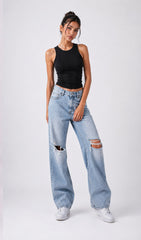 Woman wearing a black tank top and light blue jeans with rips on a white background.black tank top, black tank top women, women's black tank top, black sleeveless top, black camisole top, black vest top women, black summer top, basic black tank top, fitted black tank top, ribbed black tank top, casual black top, trendy black tank top, women's fashion top, black top for women, ladies black top, stylish black tank top, black crop tank top, everyday tank top, minimalist fashion, casual women's wear.